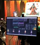 image of a computer screen with large screen behind it showing AI generated imagery with people performing in front of it and operating computers at a desk