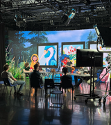 People in a Virtual Production studio with screen displaying live artwork
