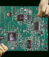 Two ceramic-like hands grip and pull on delicate threads that emerge from a "woven circuit board." The contrast between the rigid, heavy material of the hands and the soft, fragile threads creates a visual paradox, symbolising the insertion of human touch into the mechanised world. The image evokes a sense of personified anonymity, questioning whose histories and labours are being revealed or concealed when the threads of technology are pulled.