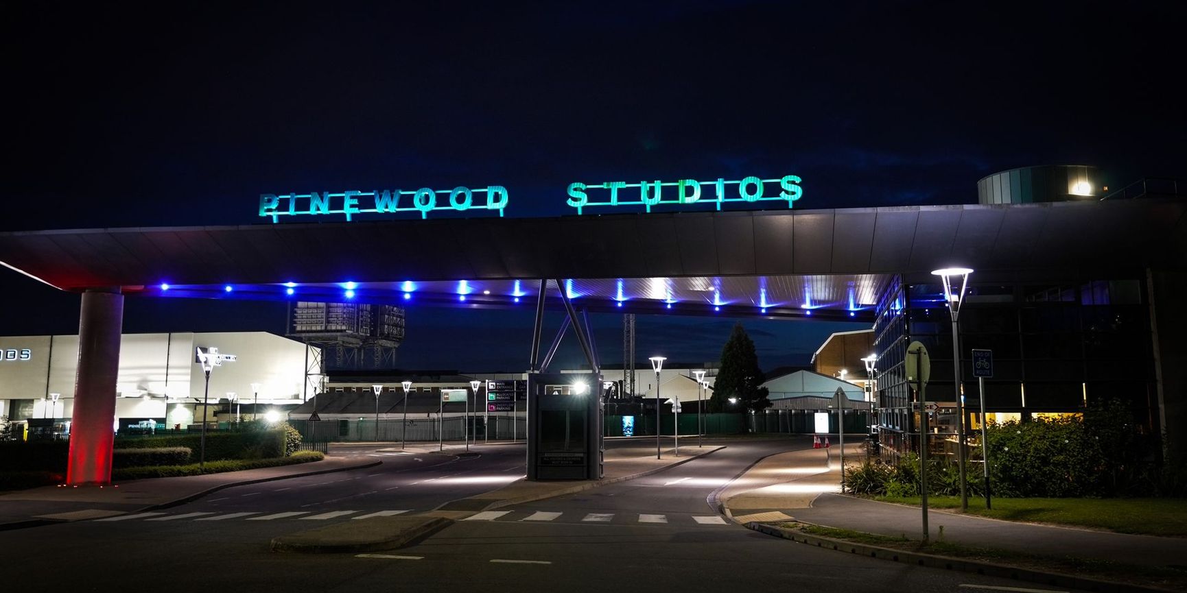 The iconic illuminated entrance gate at Pinewood Studios, Buckinghamshire, at night – the future home of the CoSTAR National Lab flagship stage