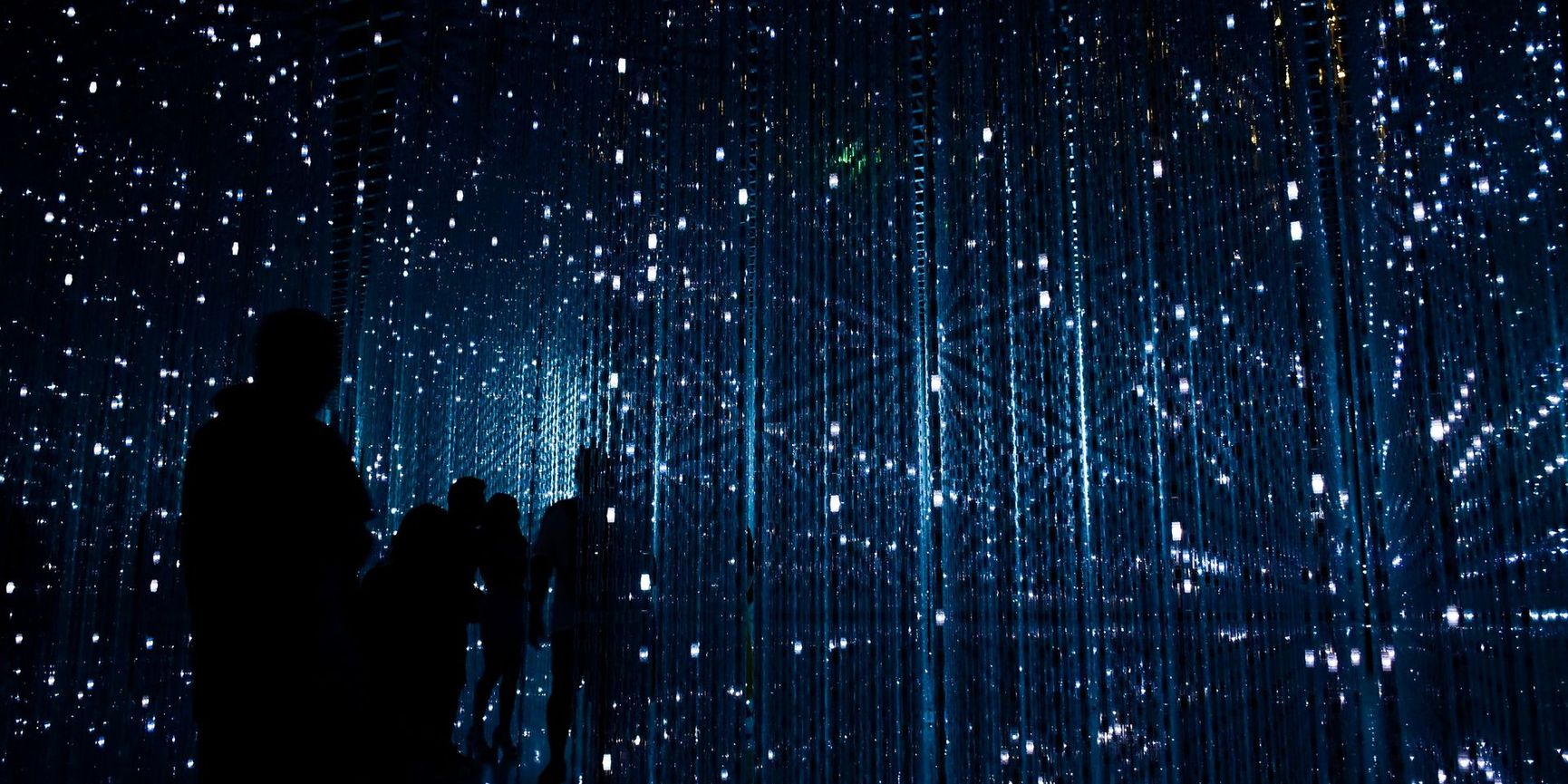 A person in a darkened space surrounded by large immersive digital projections, representing the kind of audience experiences being shaped by CoSTAR AI research