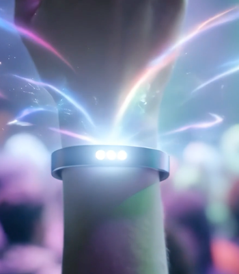 A hand wearing a smart wristband with light emanating from it 
