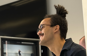 two men working in a production studio with a camera and a computer