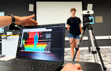 Workshop-AI for Film and Digital Content Production Hero - woman standing in a room with limb difference and computer showing heat map
