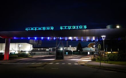 The iconic illuminated entrance gate at Pinewood Studios, Buckinghamshire, at night – the future home of the CoSTAR National Lab flagship stage