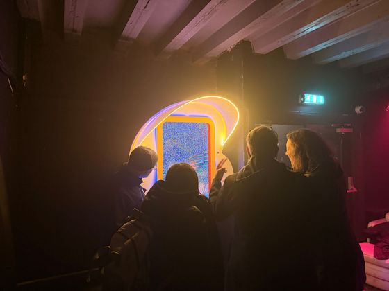 People gather round silhouetted against a TeleSync portal in Liverpool