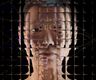 A photographic rendering of a simulated middle-aged white woman against a black background, seen through a refractive glass grid and overlaid with a distorted diagram of a neural network.
